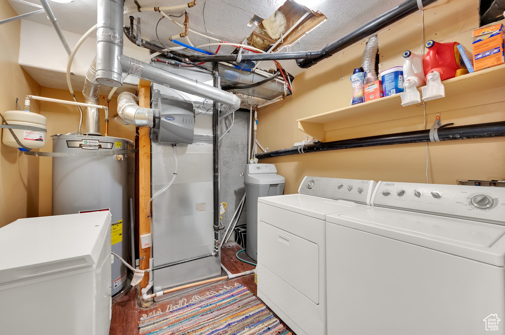 Laundry room featuring washer and clothes dryer and water heater