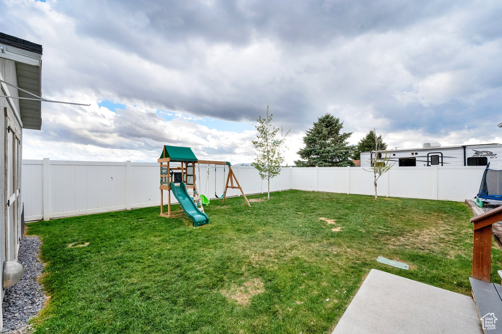 View of yard with a fenced backyard and a playground