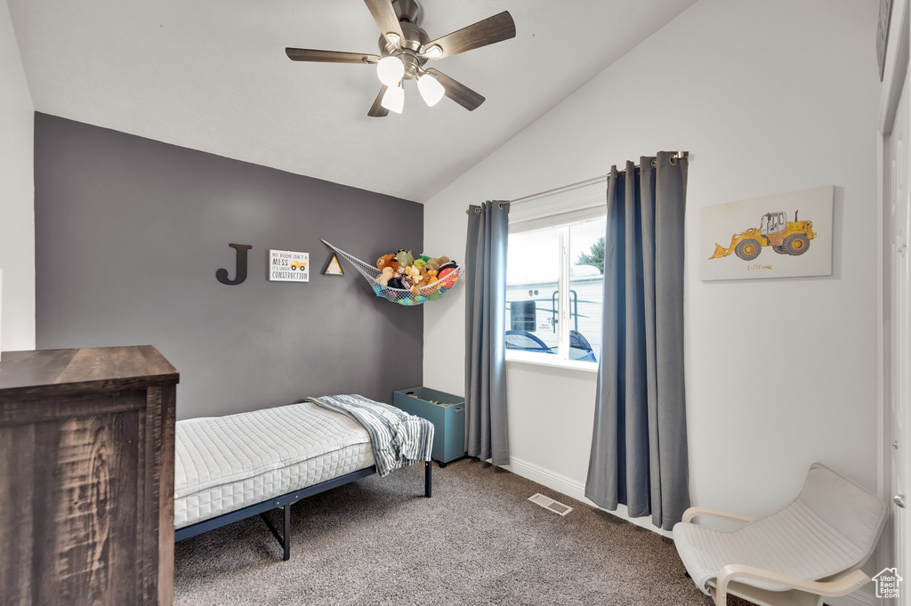 Carpeted bedroom featuring baseboards, visible vents, a ceiling fan, and lofted ceiling
