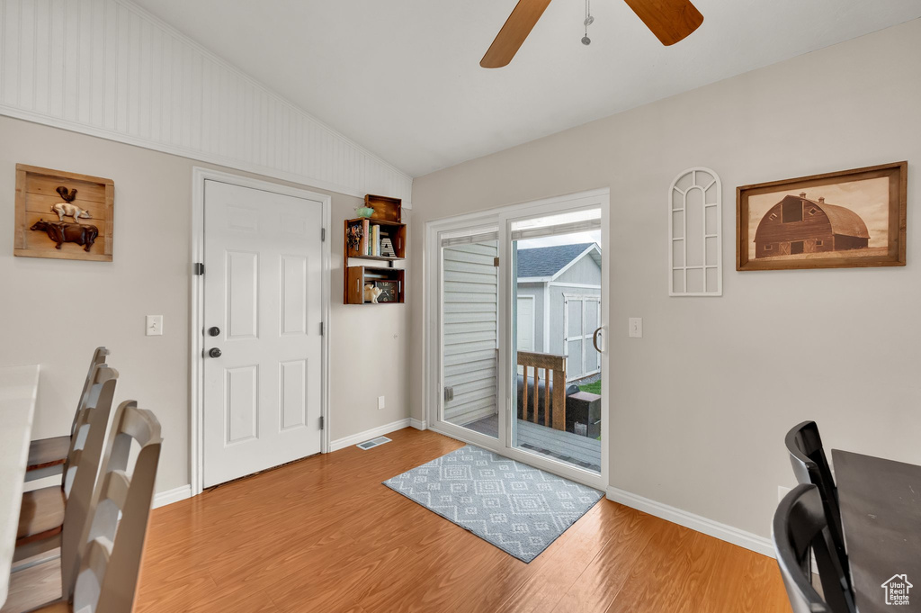 Entrance foyer featuring a ceiling fan, baseboards, wood finished floors, vaulted ceiling, and visible vents