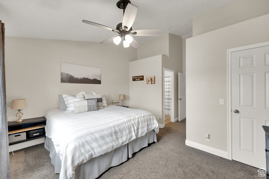 Carpeted bedroom featuring baseboards, ceiling fan, and vaulted ceiling