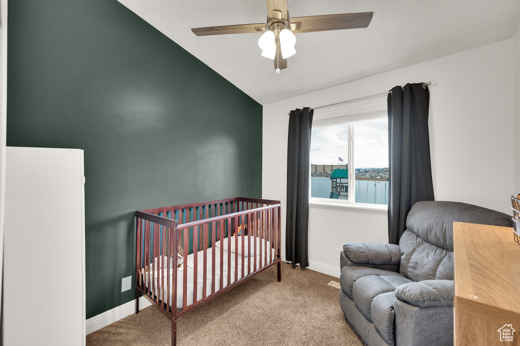 Carpeted bedroom featuring baseboards, a ceiling fan, and lofted ceiling