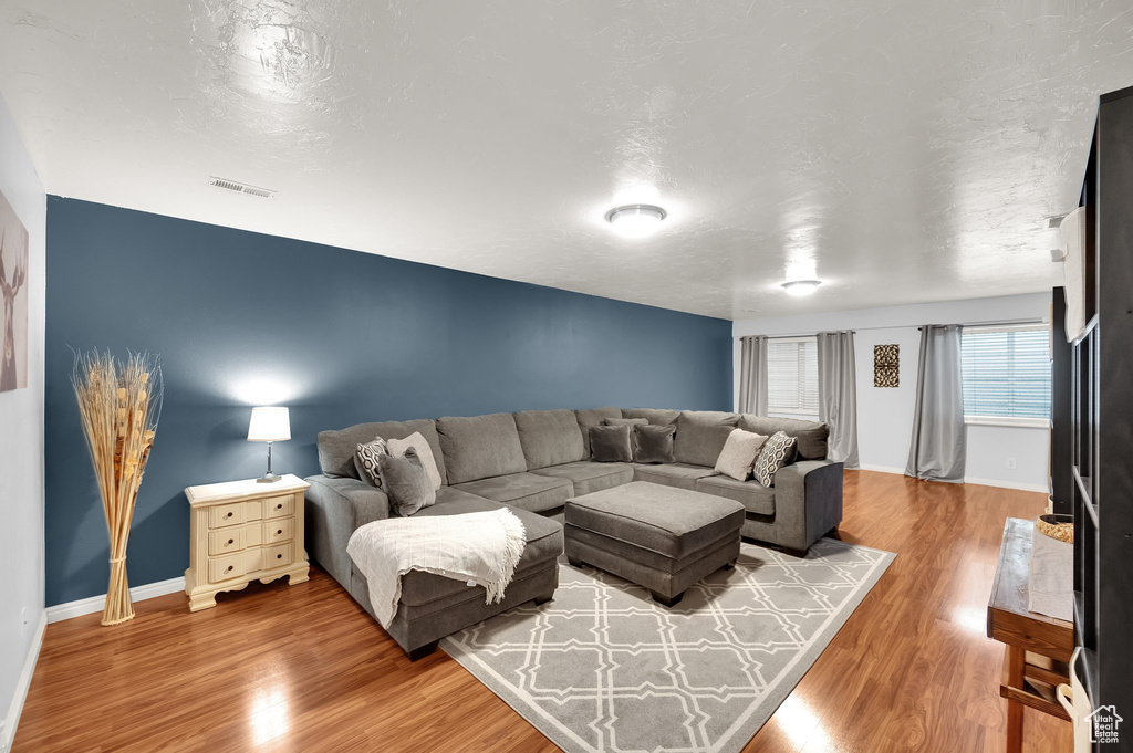 Living room featuring baseboards, wood finished floors, and visible vents