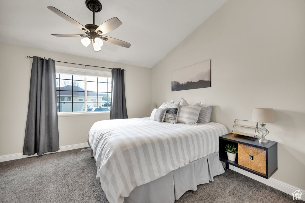 Carpeted bedroom featuring baseboards, ceiling fan, and lofted ceiling