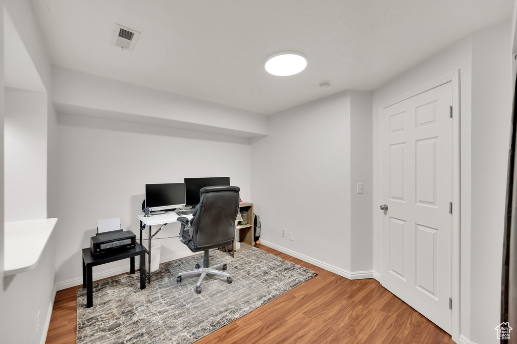 Office space featuring visible vents, baseboards, and wood finished floors