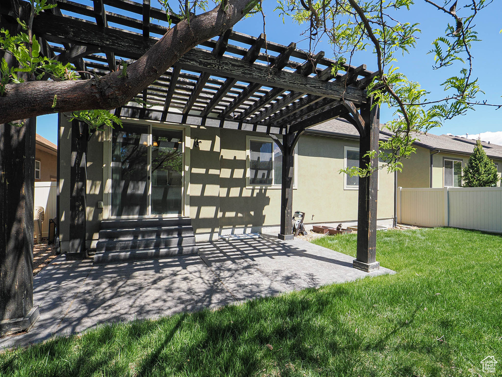 View of property\'s community with a patio, fence, a yard, a pergola, and entry steps
