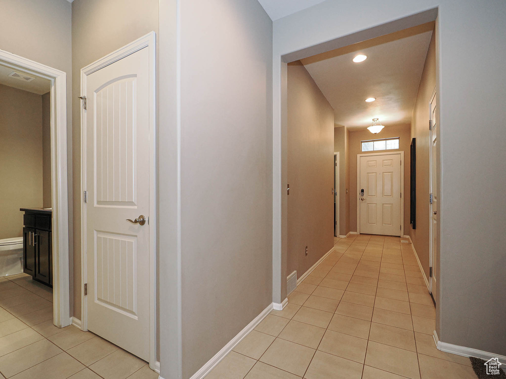 Corridor with recessed lighting, baseboards, visible vents, and light tile patterned floors