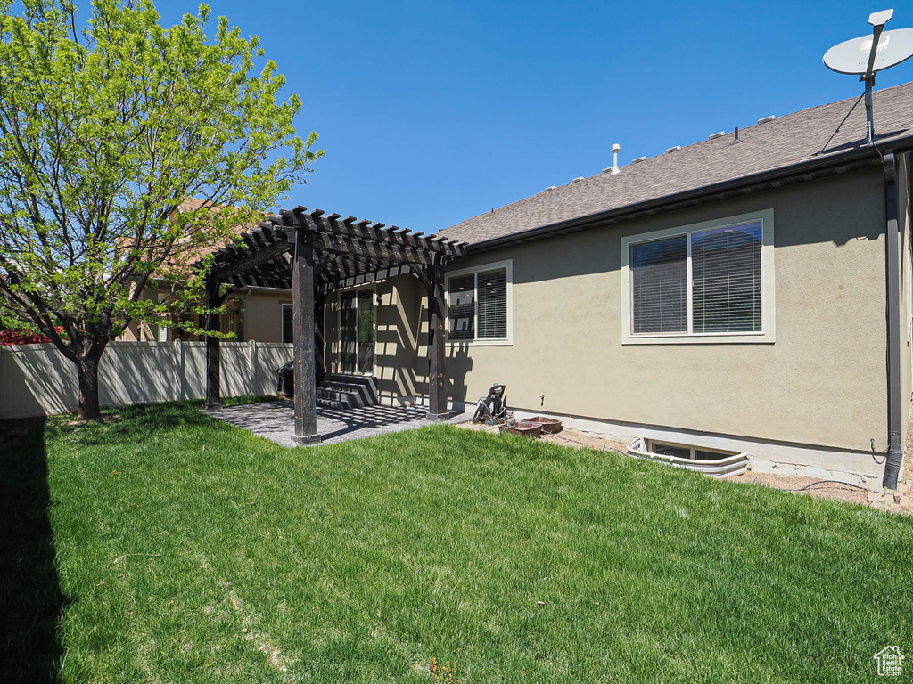 Rear view of house with fence, a pergola, a lawn, and a patio area