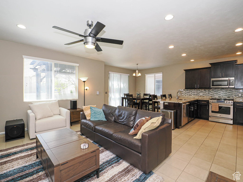 Living area featuring a ceiling fan, recessed lighting, and light tile patterned flooring