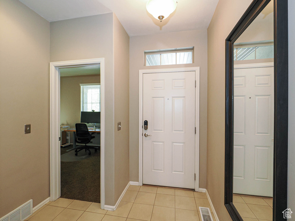 Foyer with baseboards, visible vents, and light tile patterned floors