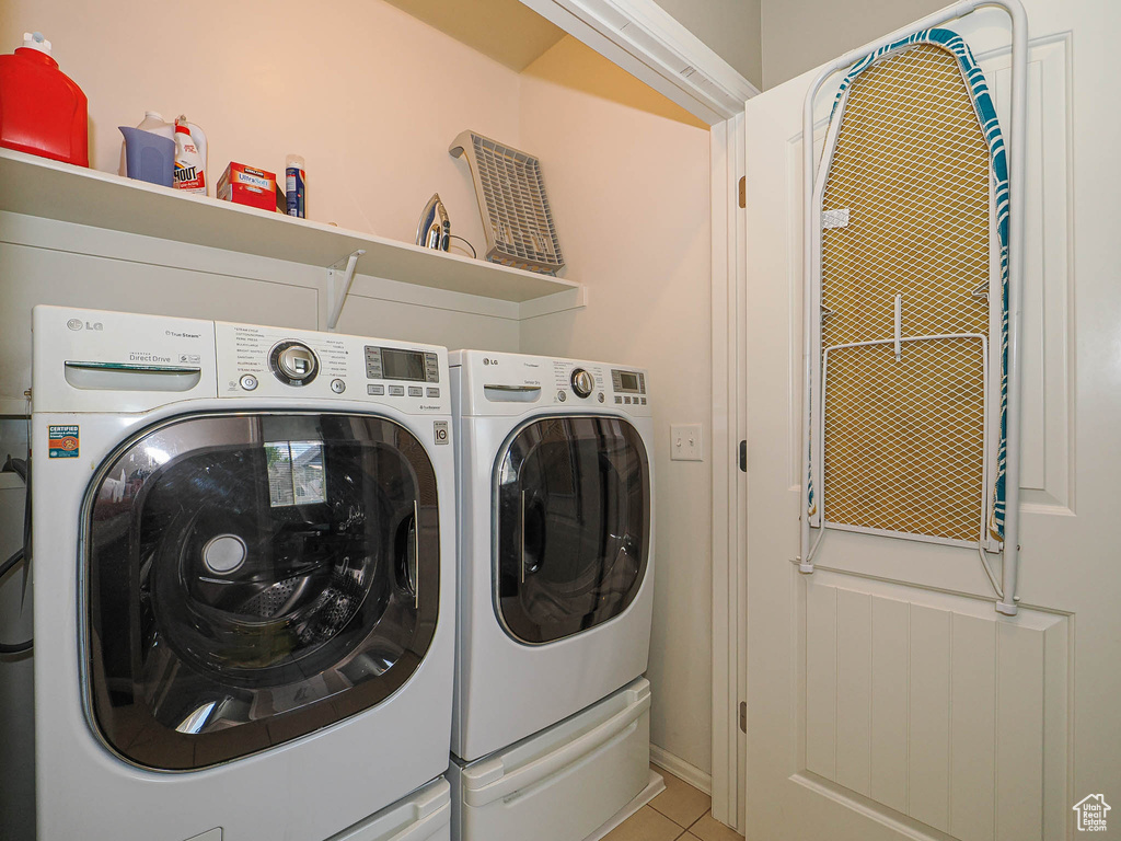 Laundry area featuring separate washer and dryer and light tile patterned floors