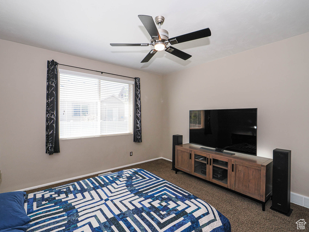 Carpeted living room featuring baseboards and a ceiling fan