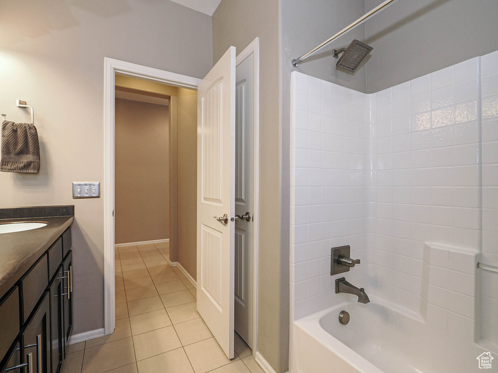 Bathroom with baseboards, shower / bathtub combination, tile patterned floors, and vanity