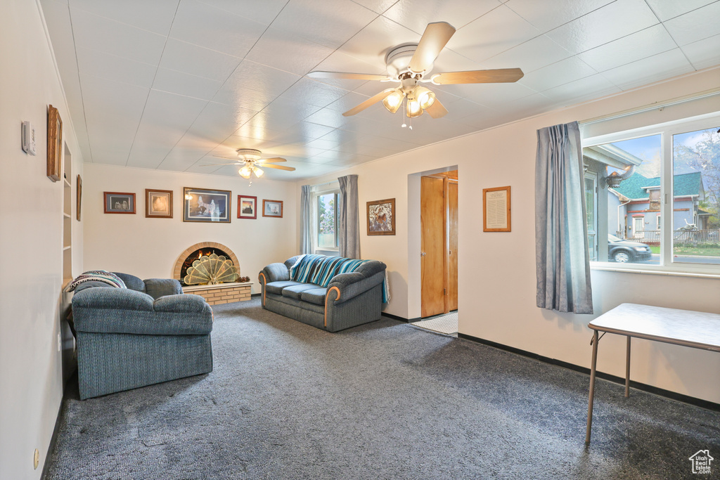 Living area featuring ceiling fan, carpet, and baseboards