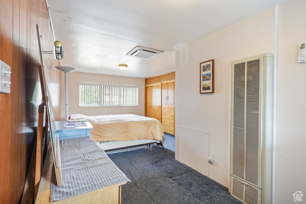 Bedroom featuring a heating unit and carpet floors