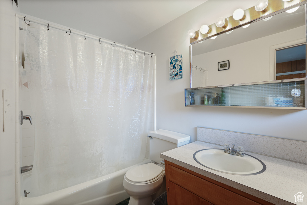 Full bath featuring shower / bathtub combination with curtain, toilet, and vanity