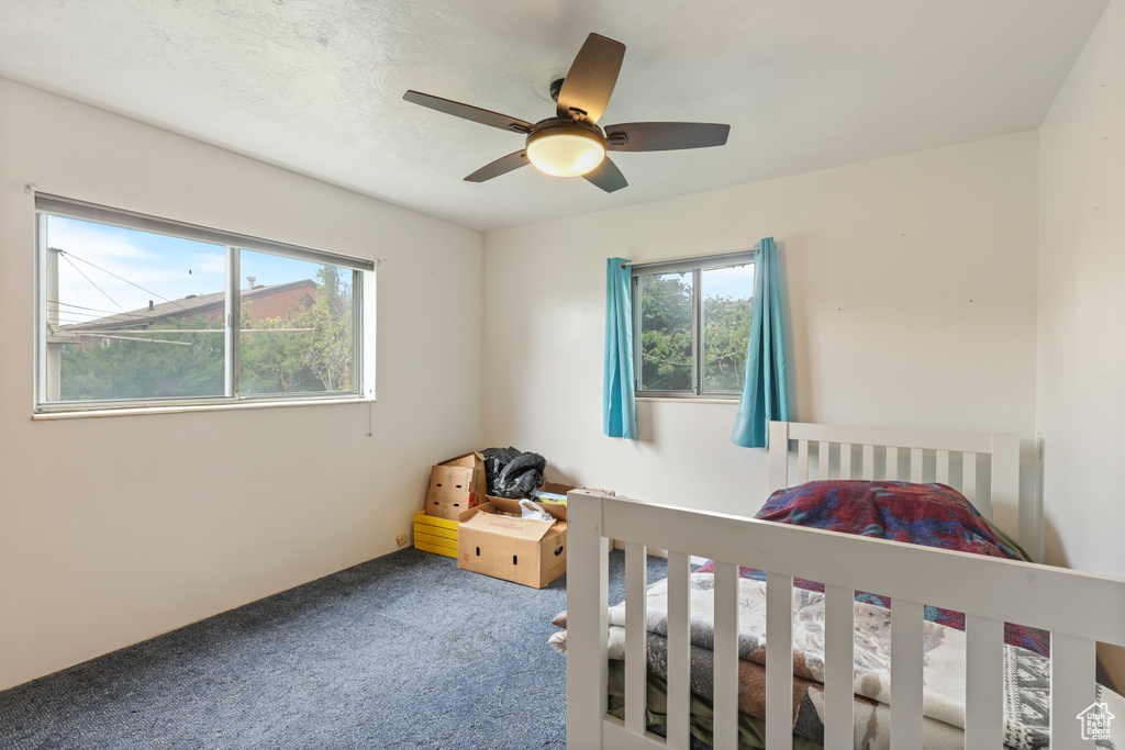 Bedroom with a ceiling fan and carpet flooring