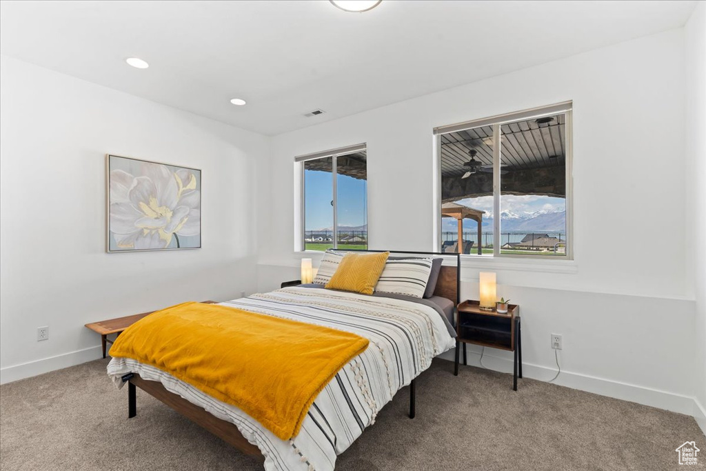 Carpeted bedroom with recessed lighting, baseboards, and multiple windows