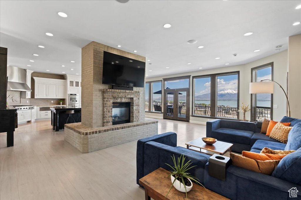 Living area with recessed lighting, light wood-style floors, and a fireplace