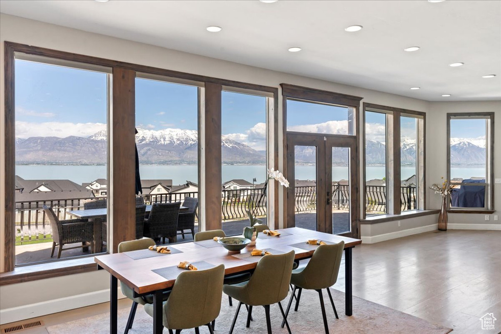 Dining space with a water view, baseboards, visible vents, and light wood-type flooring