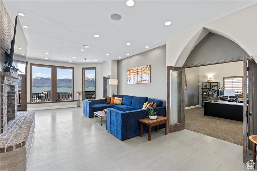 Living room featuring a brick fireplace, recessed lighting, plenty of natural light, and light wood finished floors