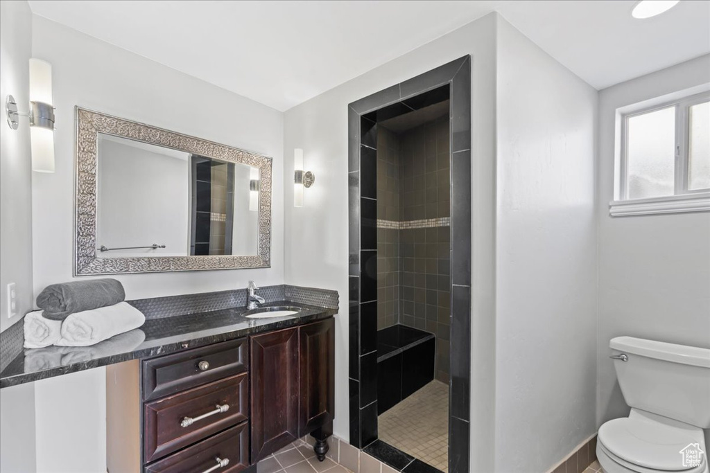 Bathroom with vanity, toilet, and tiled shower