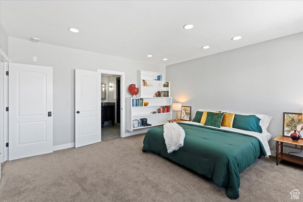 Carpeted bedroom featuring baseboards, recessed lighting, and ensuite bath