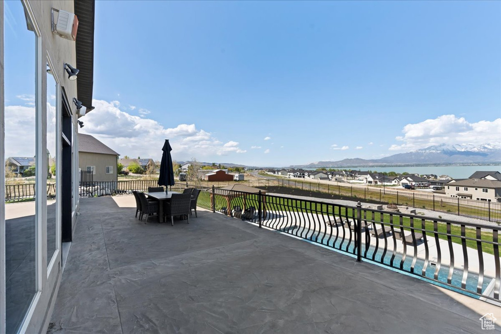 View of patio with outdoor dining area, a mountain view, a fenced backyard, and a pool