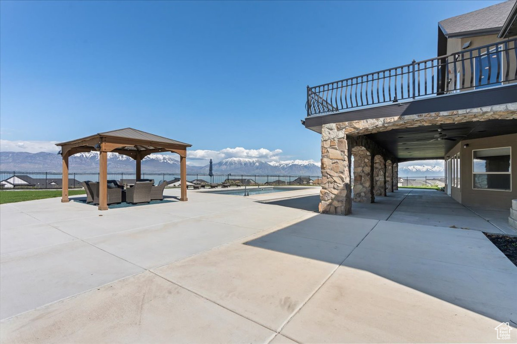 View of patio with a ceiling fan, a gazebo, a mountain view, a balcony, and outdoor lounge area