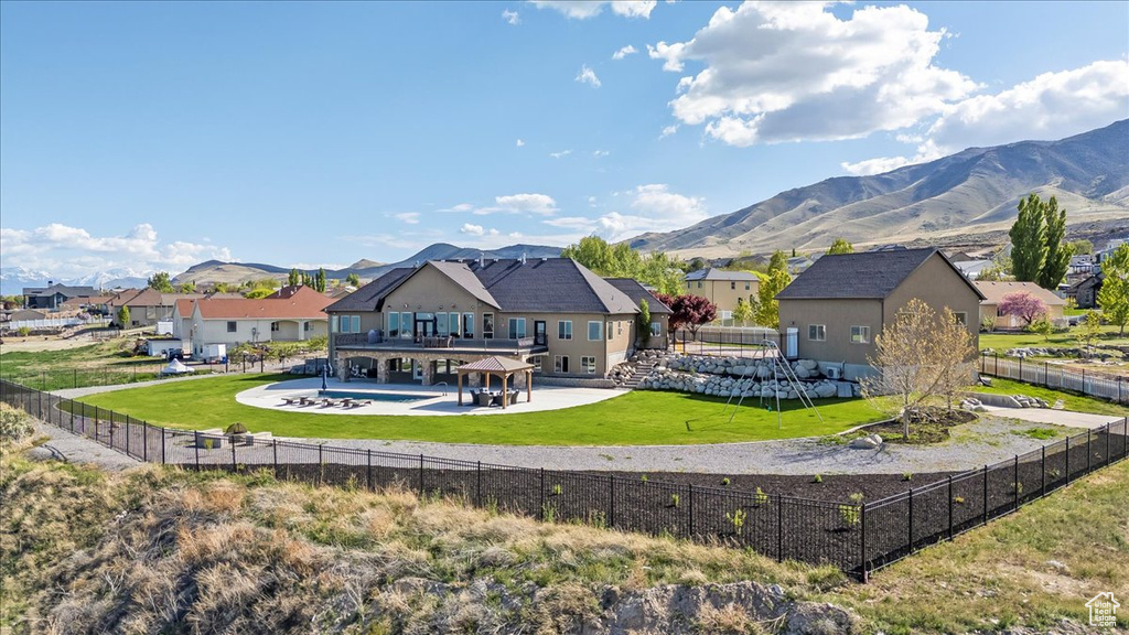 Back of property with a residential view, a fenced backyard, a fenced in pool, a mountain view, and a patio