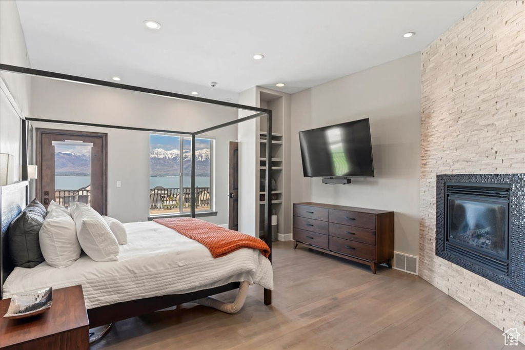 Bedroom featuring visible vents, a fireplace, wood finished floors, access to outside, and recessed lighting