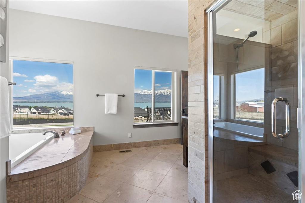 Bathroom with a shower stall, a healthy amount of sunlight, and tile patterned flooring