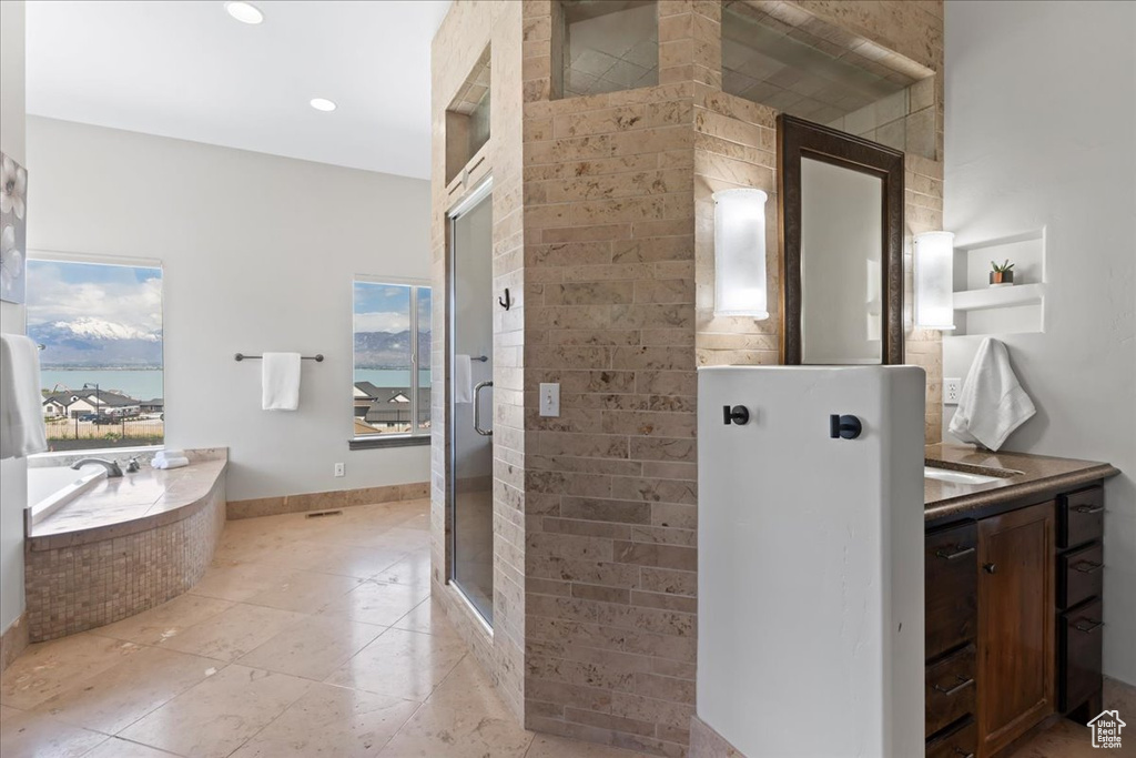 Full bath with a bath, tile patterned flooring, a shower stall, vanity, and a water view