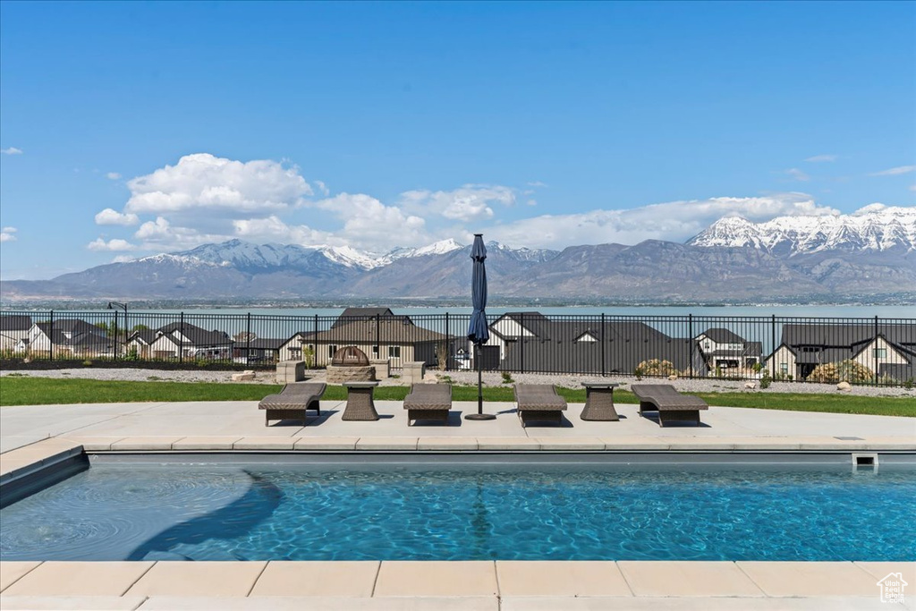 View of pool with fence, a fenced in pool, a mountain view, and a patio