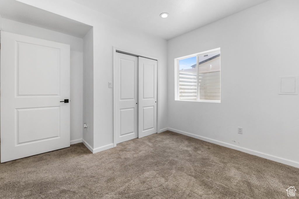 Unfurnished bedroom featuring a closet, baseboards, carpet flooring, and recessed lighting
