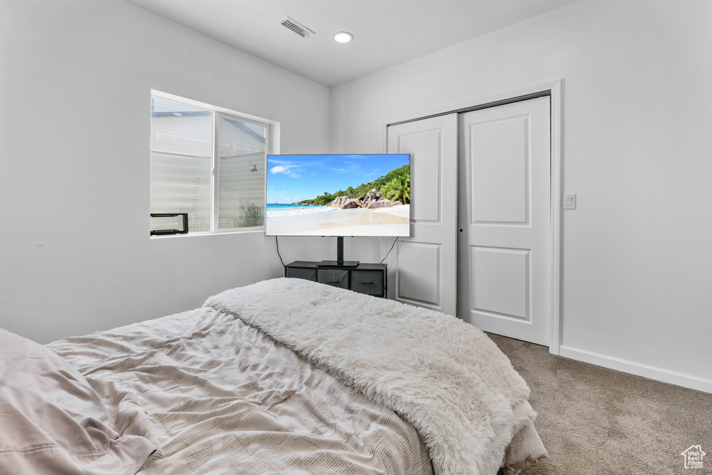 Bedroom featuring visible vents, carpet flooring, baseboards, and a closet