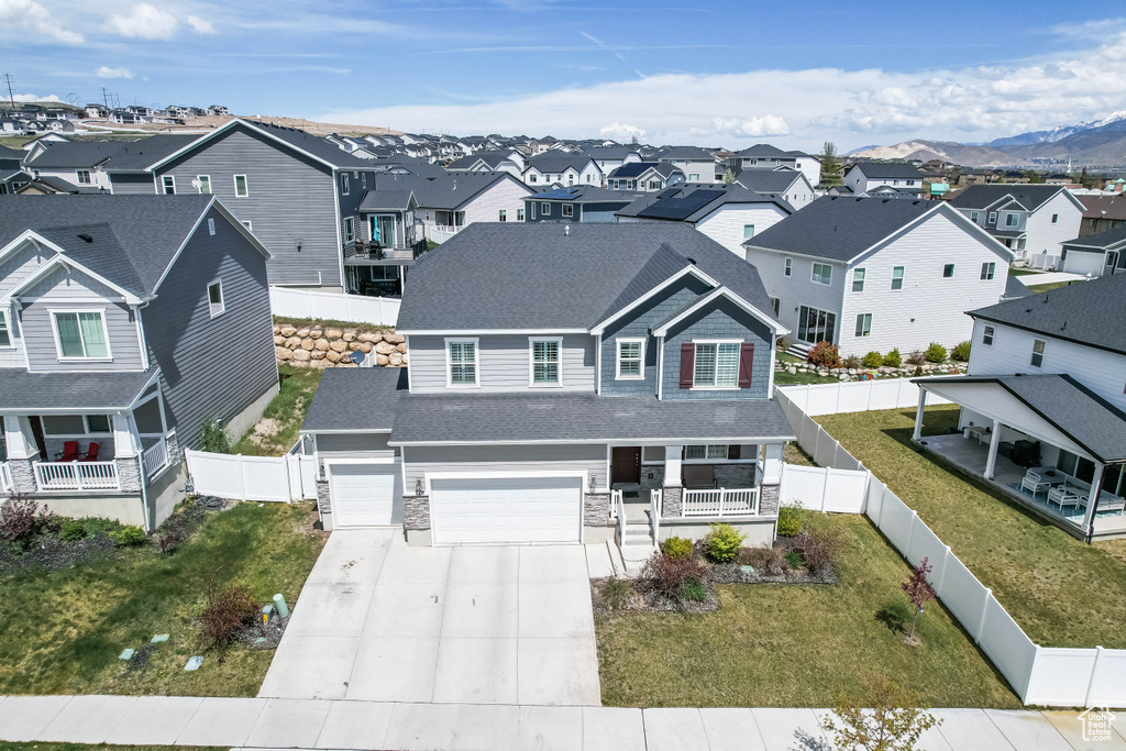 View of front of home featuring a garage, a front yard, concrete driveway, a porch, and a residential view