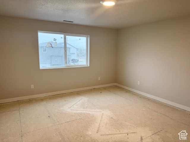 Unfurnished room featuring baseboards and visible vents