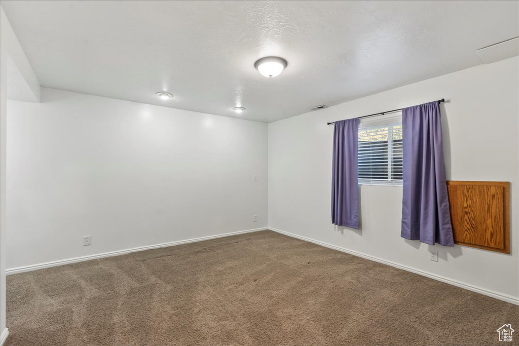 Unfurnished room featuring carpet floors, baseboards, and visible vents