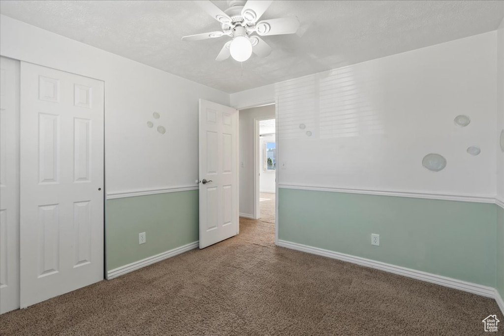Unfurnished bedroom with a ceiling fan, baseboards, carpet, and a closet