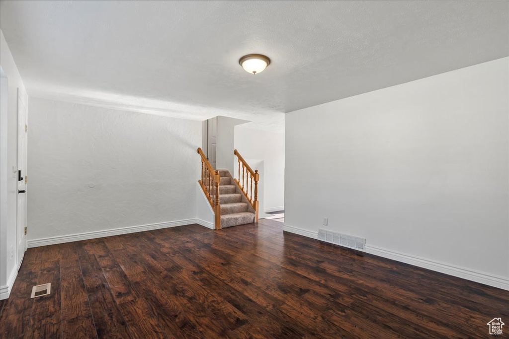 Interior space featuring stairway, baseboards, wood finished floors, and visible vents