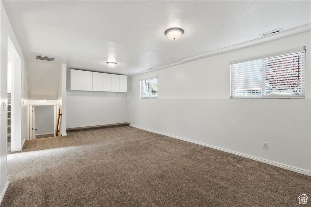 Basement featuring baseboards, visible vents, and carpet