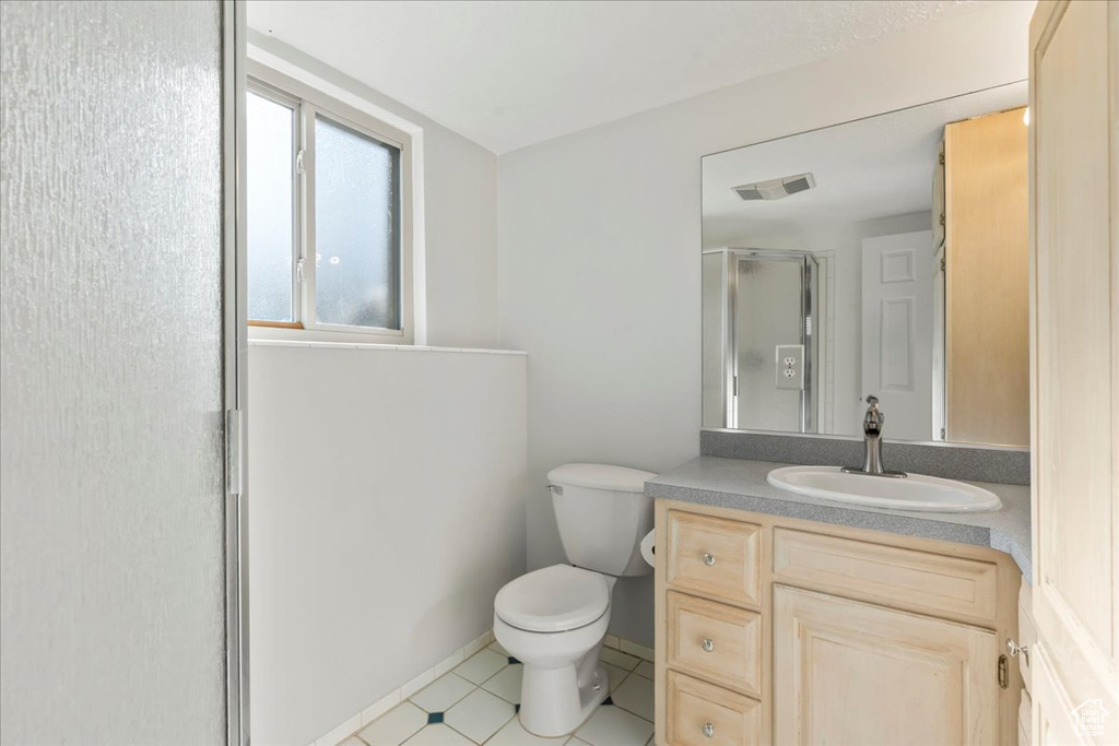 Full bath featuring vanity, toilet, tile patterned floors, visible vents, and a stall shower