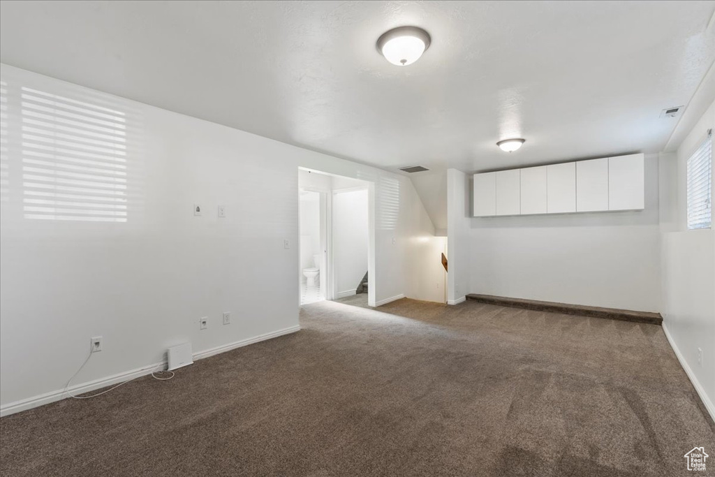 Unfurnished room featuring stairway, carpet floors, baseboards, and visible vents