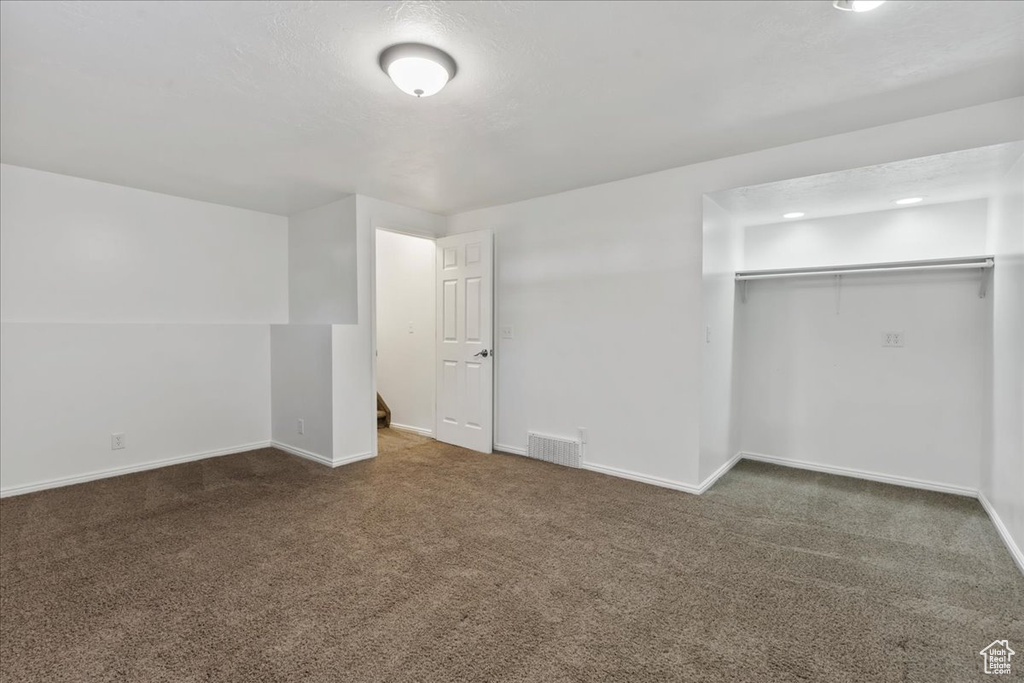 Unfurnished bedroom with baseboards, carpet, a closet, and visible vents