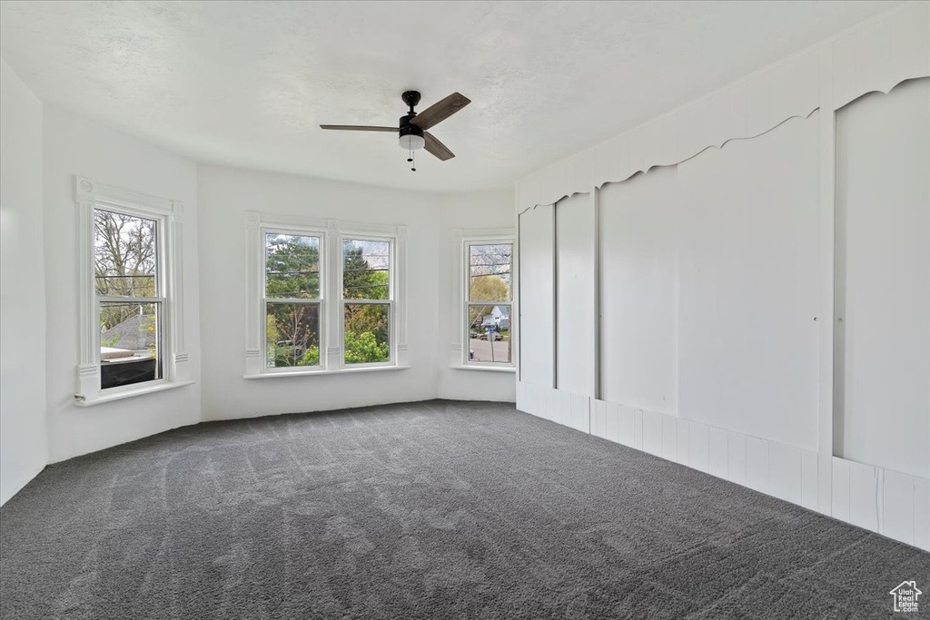 Unfurnished room featuring ceiling fan and carpet