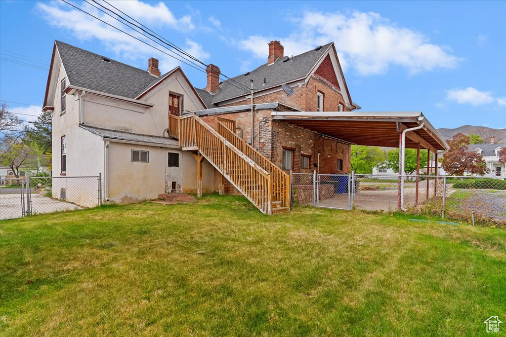 Rear view of property featuring a gate, a fenced backyard, and stucco siding