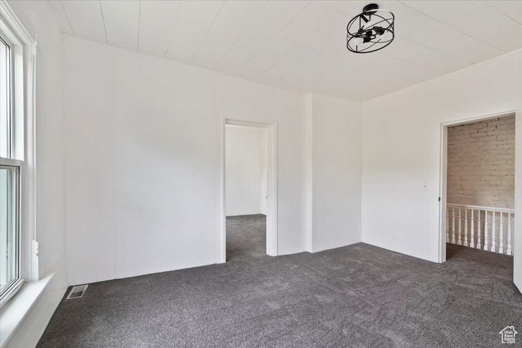 Unfurnished room with carpet floors, plenty of natural light, and visible vents
