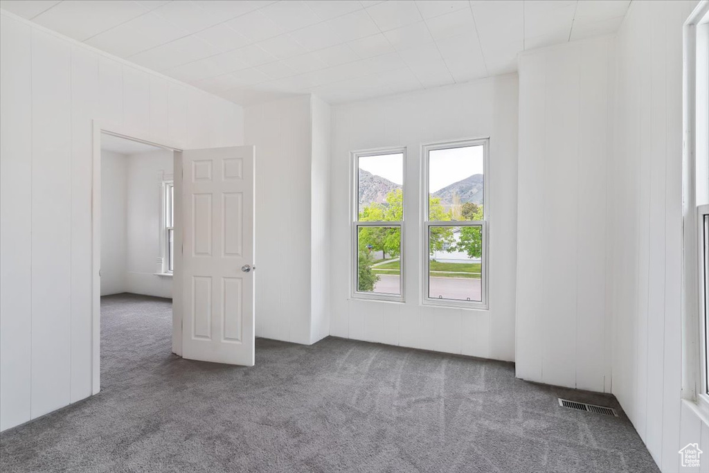 Unfurnished room with visible vents and carpet