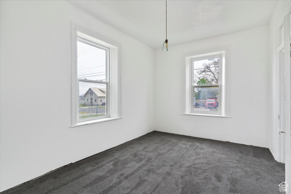 Spare room featuring dark colored carpet